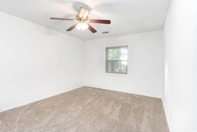 spare room with visible vents, a ceiling fan, baseboards, and carpet floors