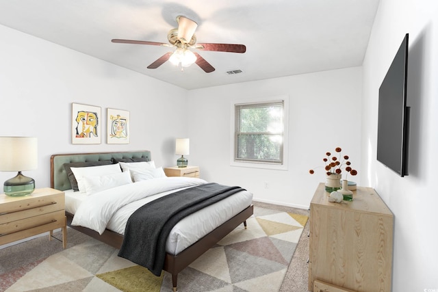 bedroom featuring visible vents, a ceiling fan, and light carpet