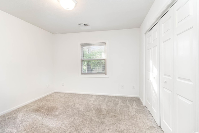 unfurnished bedroom featuring baseboards, a closet, and carpet flooring