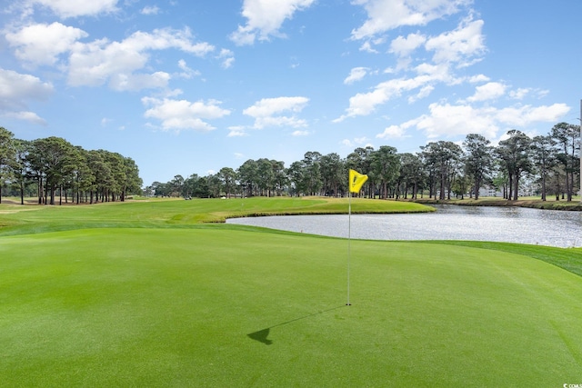 view of home's community with a lawn, a water view, and golf course view