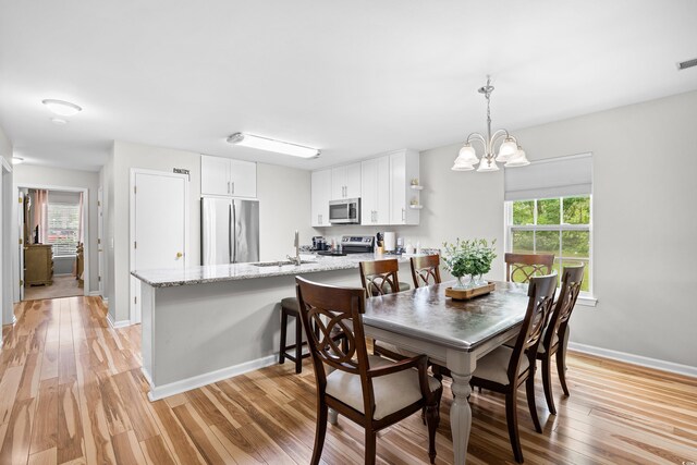 1204 River Oak Dr Unit 25-A, Myrtle Beach, SC 29579 - dining space featuring light wood-style flooring, a chandelier, and baseboards