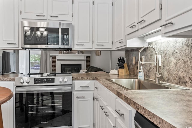 kitchen featuring a sink, appliances with stainless steel finishes, and white cabinetry