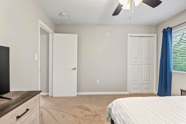 bedroom with baseboards, a ceiling fan, a closet, and carpet flooring