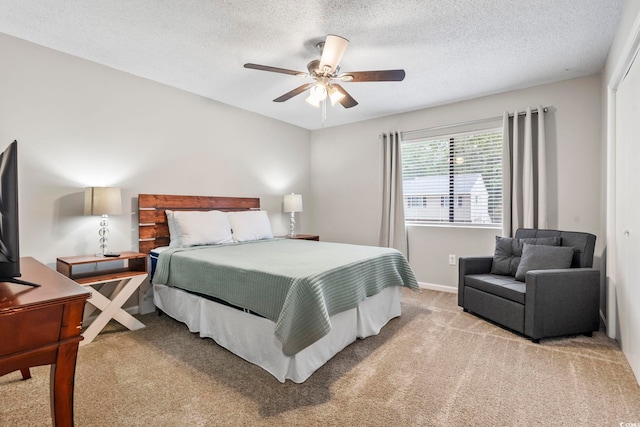 bedroom with a textured ceiling, ceiling fan, and light colored carpet