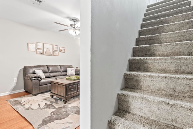 stairway with baseboards, visible vents, wood finished floors, and a ceiling fan