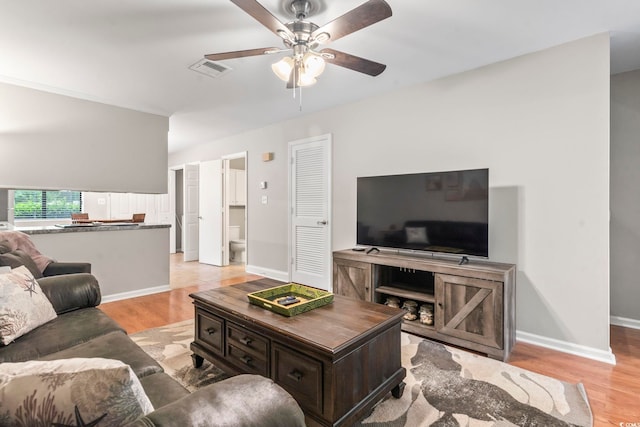 living area with a ceiling fan, visible vents, baseboards, and light wood-type flooring