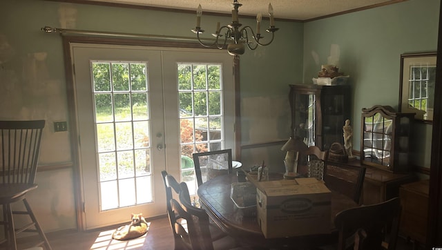 dining area featuring a healthy amount of sunlight, french doors, and a notable chandelier