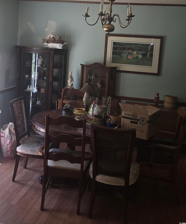 dining room with wood finished floors and a notable chandelier