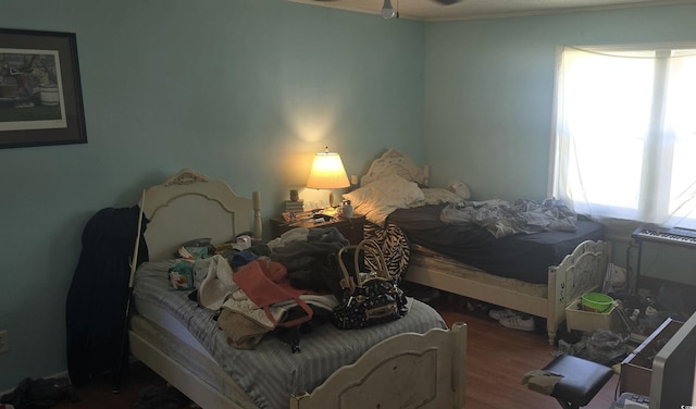 bedroom with wood finished floors and ornamental molding