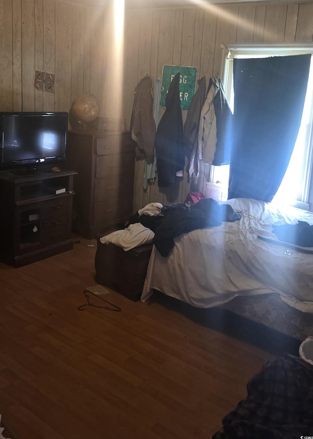 bedroom featuring wood walls and wood finished floors