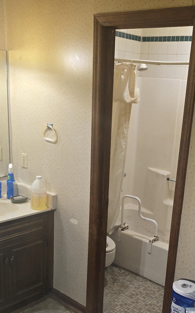bathroom featuring toilet, wallpapered walls, and vanity