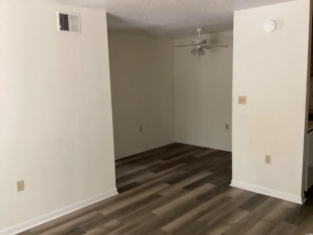 409 Salt Marsh Cir Unit 20C, Pawleys Island, SC 29585 - empty room with a ceiling fan, visible vents, baseboards, and dark wood-type flooring