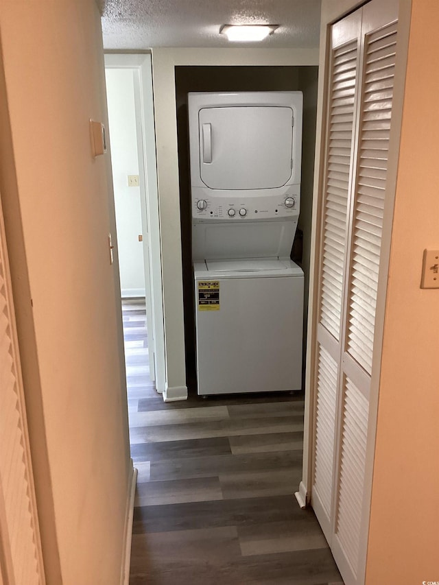 409 Salt Marsh Cir Unit 20C, Pawleys Island, SC 29585 - laundry area featuring laundry area, stacked washer / dryer, dark wood-style flooring, baseboards, and a textured ceiling