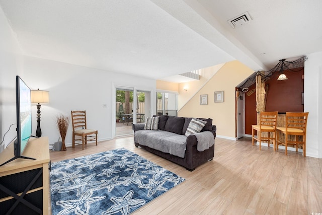 living area with visible vents, light wood finished floors, baseboards, and french doors
