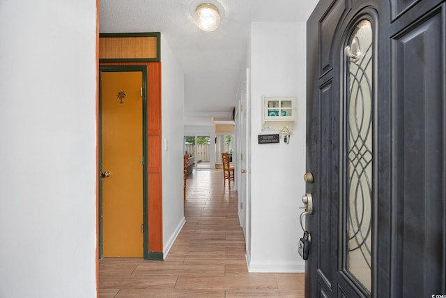 foyer with baseboards and light wood-type flooring