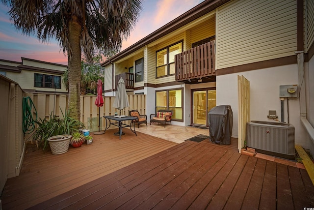 deck at dusk with fence and central AC unit