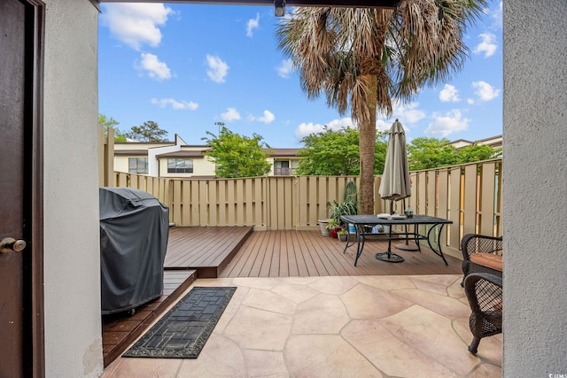 view of patio / terrace featuring area for grilling, fence, a wooden deck, and outdoor dining area
