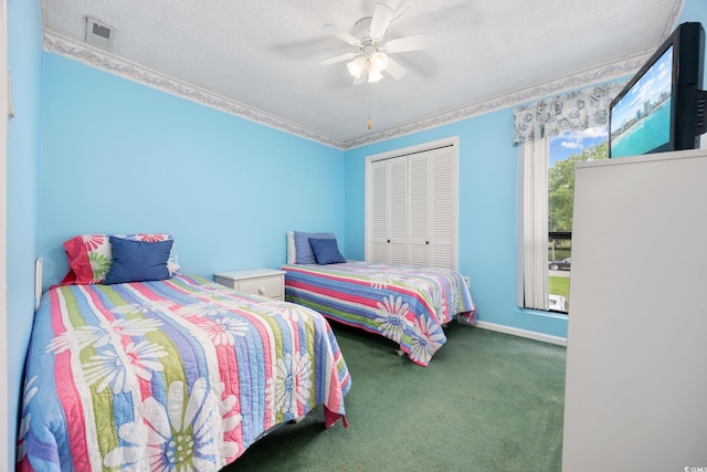 bedroom featuring a closet, carpet floors, visible vents, ceiling fan, and a textured ceiling