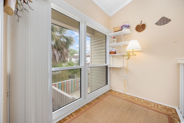 doorway featuring baseboards and ornamental molding
