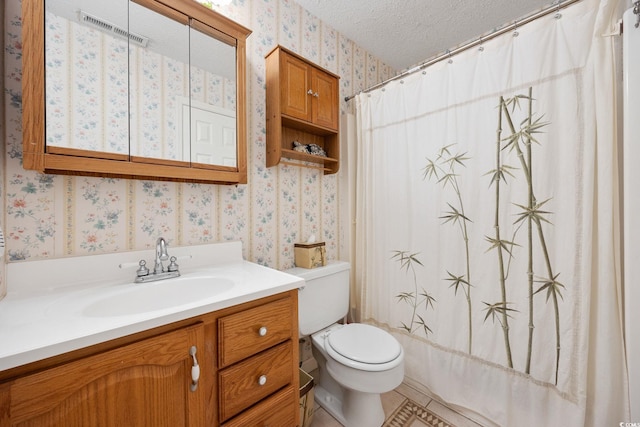 bathroom with visible vents, vanity, toilet, wallpapered walls, and a textured ceiling