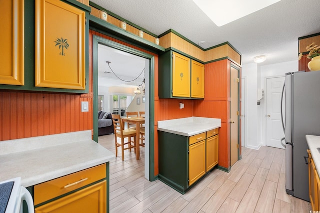 kitchen with light wood-style floors, freestanding refrigerator, stove, and light countertops