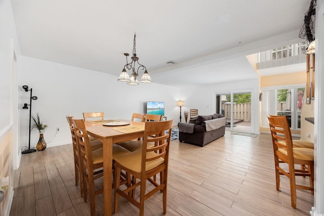 dining room with a chandelier and light wood-type flooring