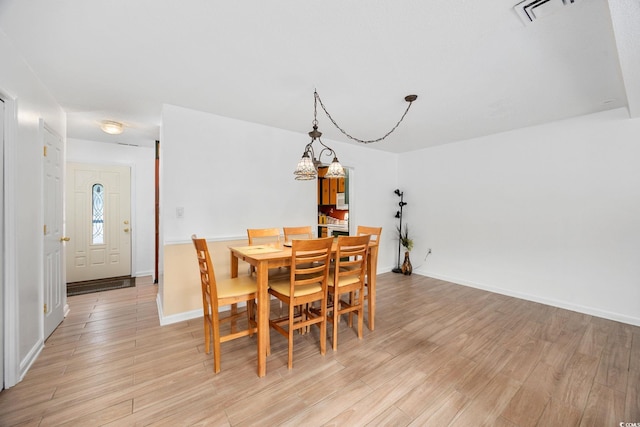 dining area featuring baseboards, light wood-type flooring, and visible vents