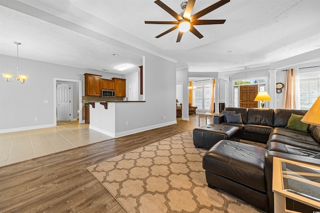 246 Laurel Bay Dr, Murrells Inlet, SC 29576 - living area featuring baseboards, crown molding, light wood finished floors, and ceiling fan with notable chandelier
