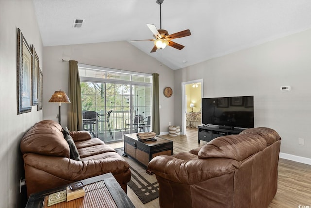 living area featuring a ceiling fan, visible vents, vaulted ceiling, baseboards, and light wood-style floors