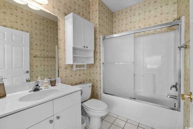 bathroom with tile patterned flooring, vanity, toilet, wallpapered walls, and bath / shower combo with glass door