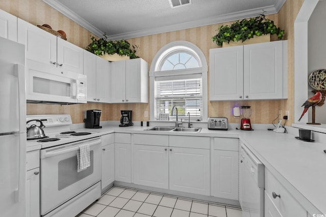 kitchen featuring white cabinets, a sink, white appliances, a textured ceiling, and wallpapered walls