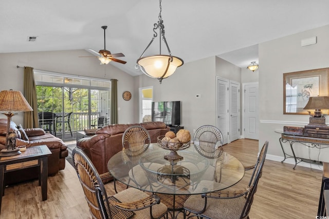 dining space with visible vents, ceiling fan, vaulted ceiling, and light wood-type flooring