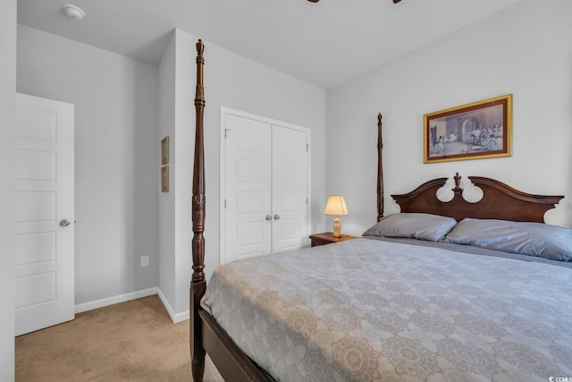 bedroom with baseboards, ceiling fan, a closet, and light colored carpet