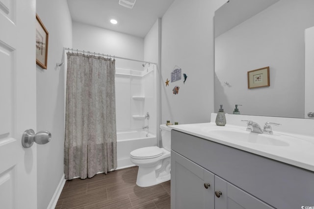 bathroom featuring wood finished floors, shower / tub combo, vanity, baseboards, and toilet