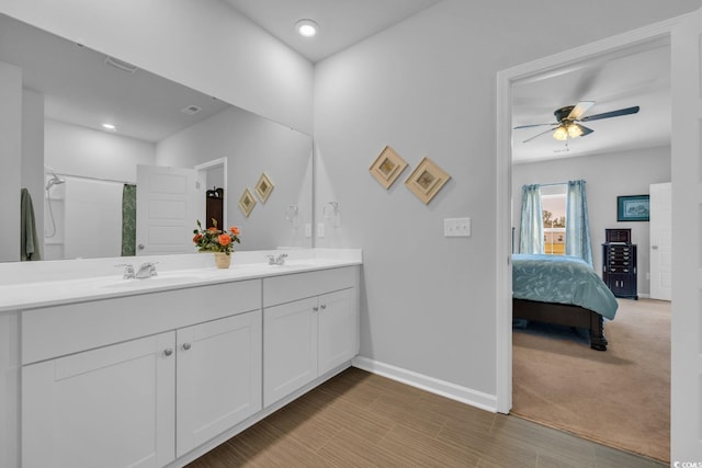 bathroom featuring baseboards, a sink, ceiling fan, and ensuite bathroom