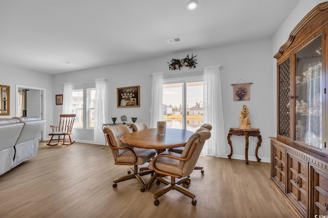 dining room with light wood-style floors, baseboards, and visible vents