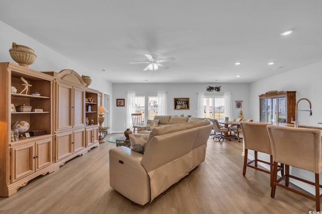 living room with recessed lighting, a ceiling fan, and light wood-style flooring