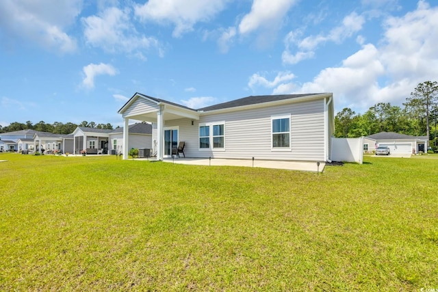 rear view of property with a lawn, a patio area, and central AC
