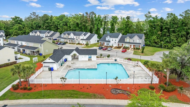 view of swimming pool with a fenced in pool, a lawn, fence, and a residential view