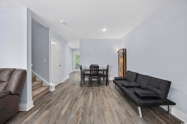 living room featuring stairway, baseboards, recessed lighting, and wood finished floors