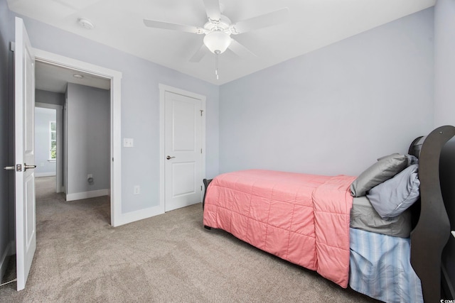 carpeted bedroom featuring baseboards and ceiling fan