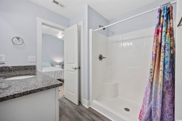 ensuite bathroom featuring vanity, ensuite bath, a shower with shower curtain, wood finished floors, and visible vents