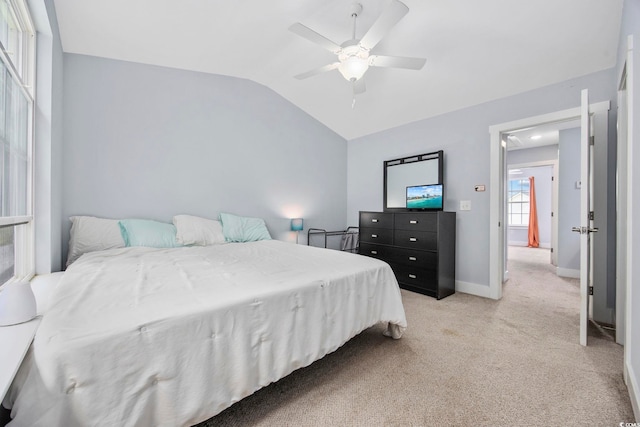 bedroom featuring ceiling fan, light colored carpet, baseboards, and lofted ceiling