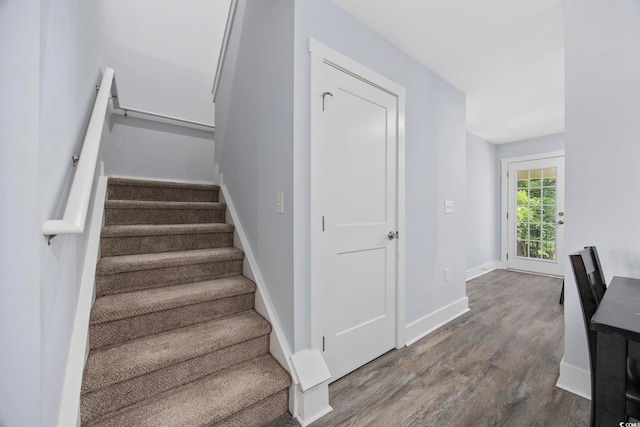 staircase with baseboards and wood finished floors