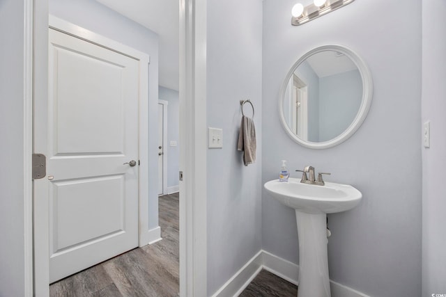 bathroom with a sink, baseboards, and wood finished floors