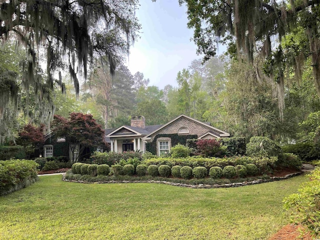 741 Tuckers Rd, Pawleys Island, SC 29585 - view of front of house with a chimney, a front lawn, and brick siding