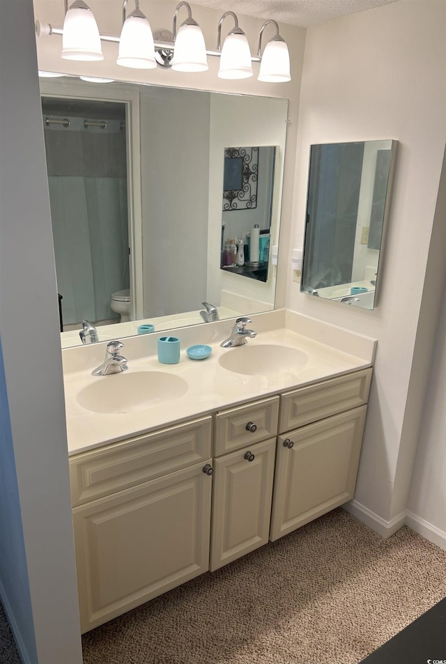 bathroom with toilet and double vanity