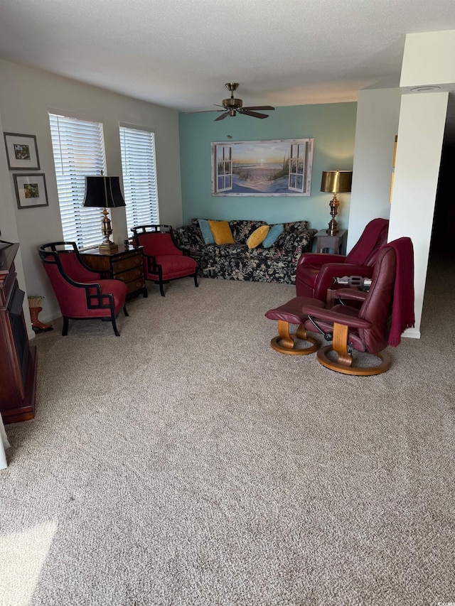 living area featuring carpet and a ceiling fan
