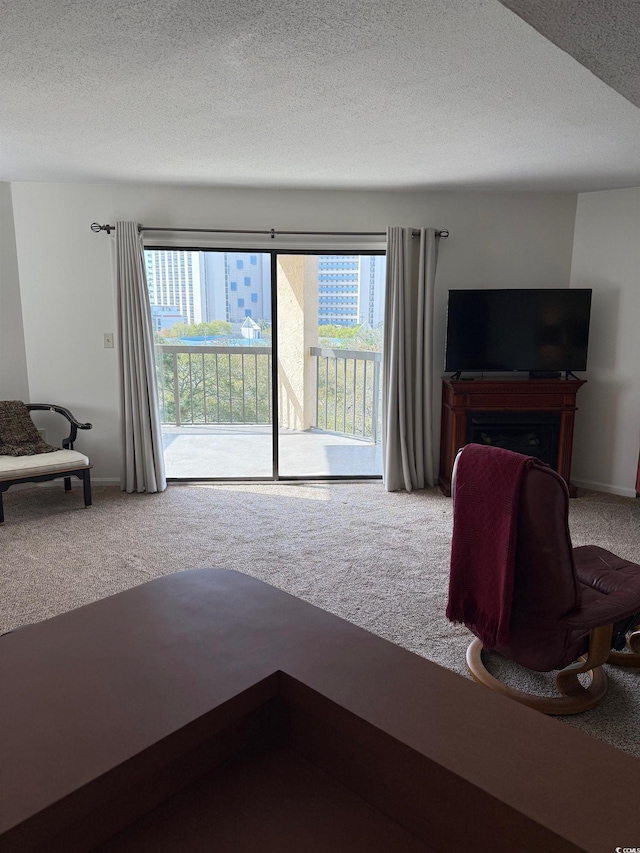 carpeted living room with plenty of natural light, a textured ceiling, and baseboards