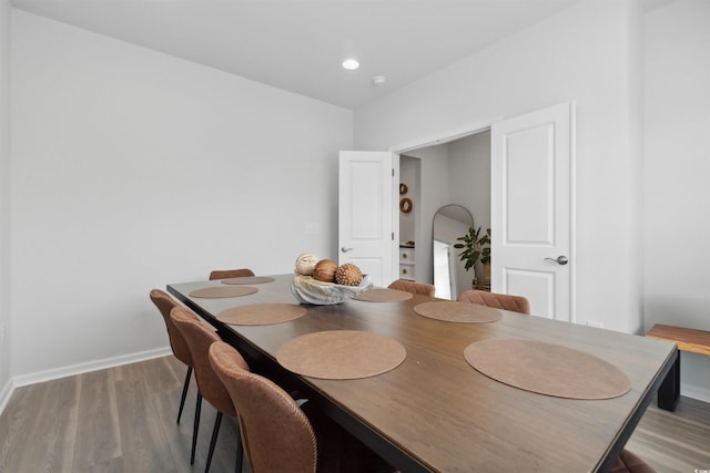 dining space featuring baseboards and wood finished floors
